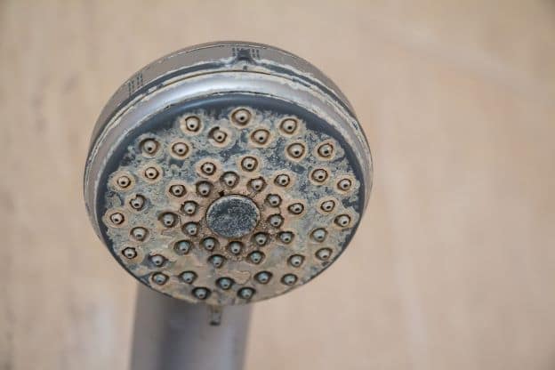hard water deposit on shower head faucet