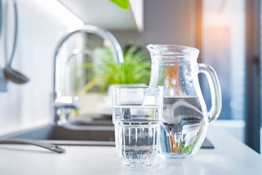purified water from the tap in a glass and pitcher